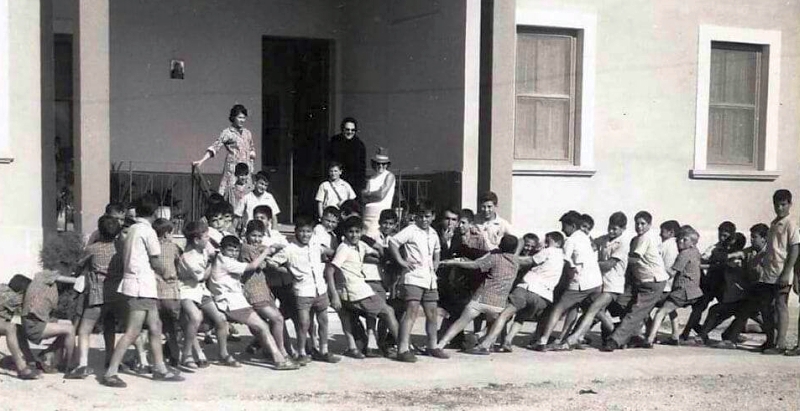 I ragazzini giocano all'esterno dell'Istituto Margiotta, dietro di loro, con il cappello, la contessa Borletti