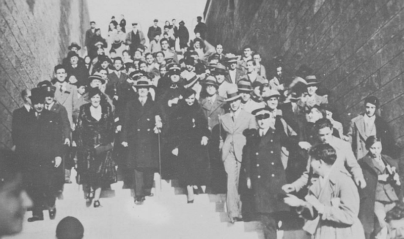 Guglielmo Marconi e alla sua destra la moglie, la marchesa Maria Cristina Bezzi-Scali, sulla scalinata del Monumento al Marinaio che porta al piazzale inferiore, dopo la visita alla mole.